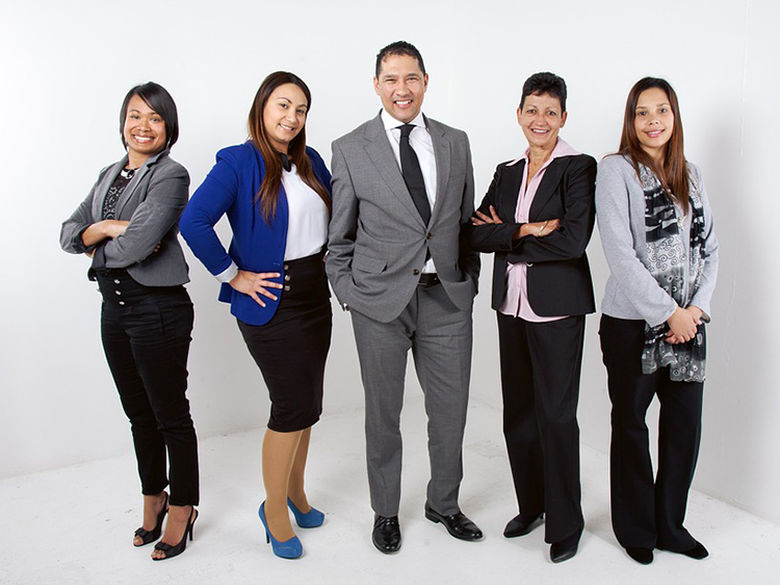 Five individuals in professional attire pose for group shot