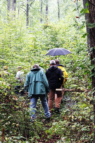 Members of the Cumberland Woodland Owners Association make their way through the forest to the foundation of the 1876 Cold Springs Hotel.