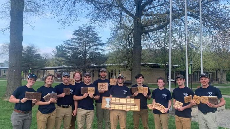 Members of the 2023 Woodsmen Team hold plaques after winning first place at the 2023 Mid-Atlantic Woodsmen's Meet