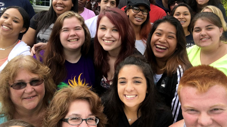 Group of students gather with staff member for selfie