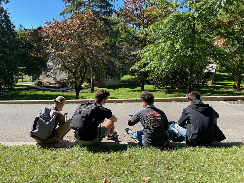 photo of Male students sitting outside 