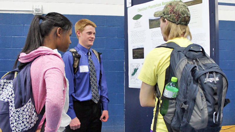 Students discuss poster display at 2016 Academic Festival