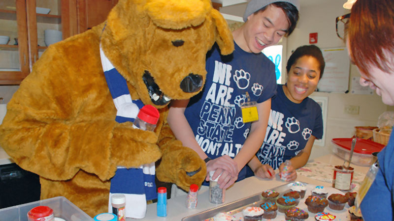 Lion Ambassadors bake muffins and cupcakes during a service project with the Nittany Lion's help