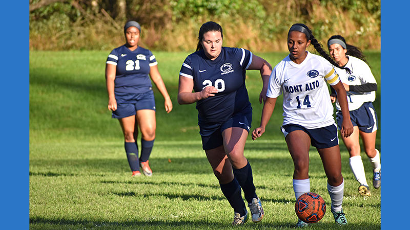 Members of women's soccer team compete against the team from another campus