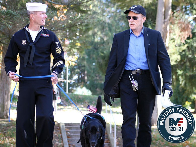 Student Veteran walks with service dog and Veteran Instructor