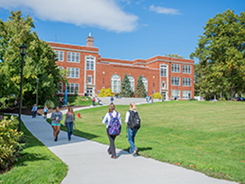 Students walk across campus on a sunny day