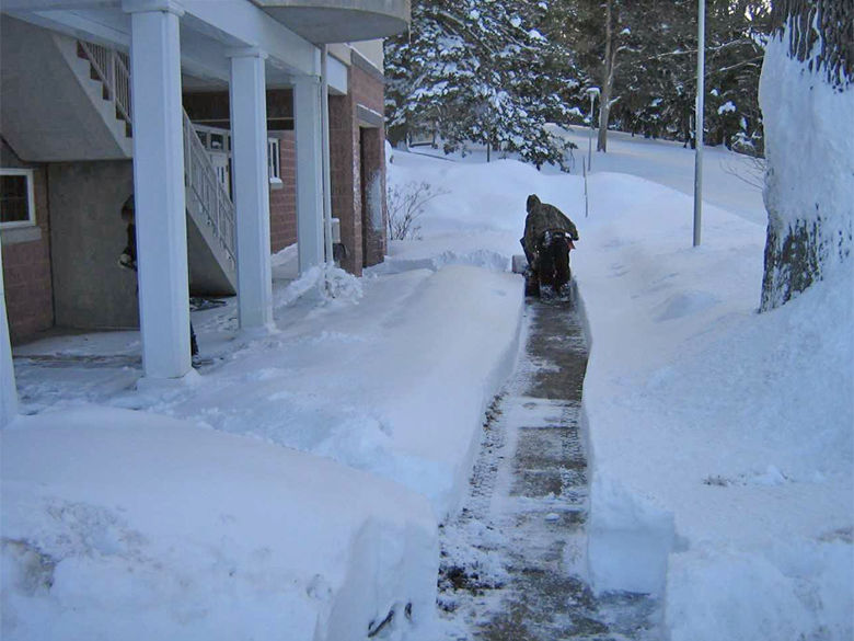 Maintenance clearing path through snow
