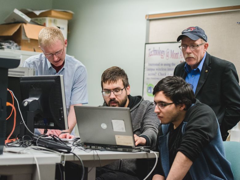 Penn State Mont Alto staff members help students at a computer workstation