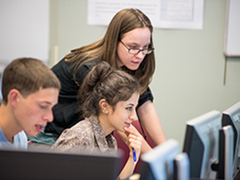 Penn State Mont Alto staff member helps a student at a computer workstation