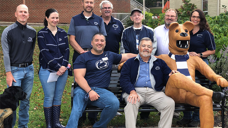Alumna on campus around lion bench 