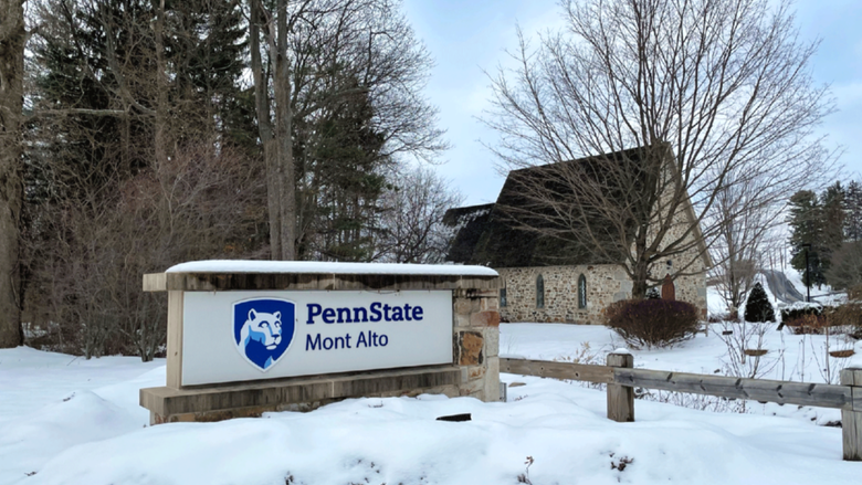 Wintry snow photo of the Emmanual Chapel and the campus sign. 