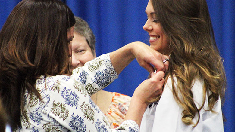 Nursing student Sidney Crain is pinned by a family member.