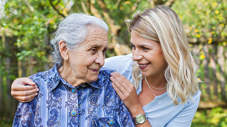 Elderly female with young lady touching shoulder
