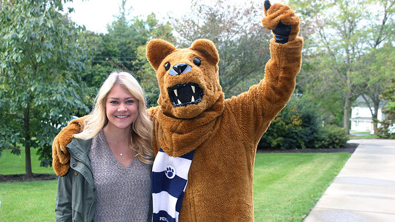 Female student stands with Nittany Lion mascot