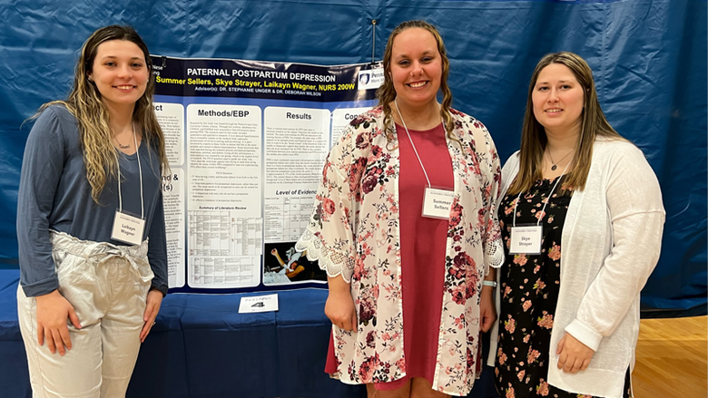 Nursing students posing with their research poster. 