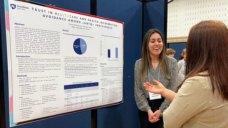 Female student discussing her research with faculty during the 2022 Academic Festival. 