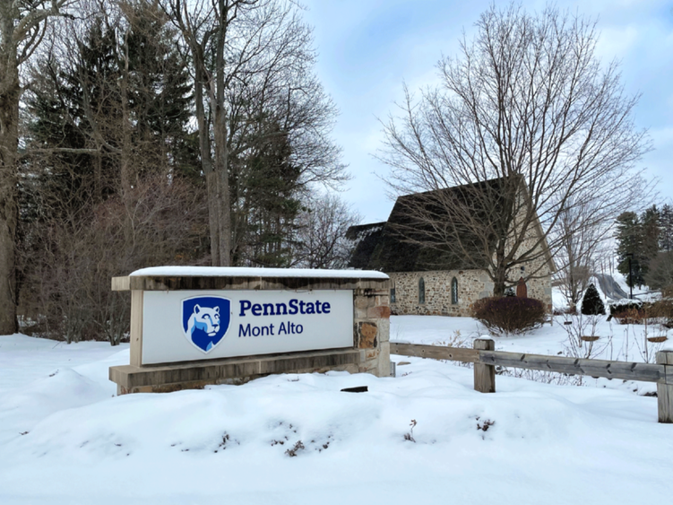 Wintry snow photo of the Emmanual Chapel and the campus sign. 