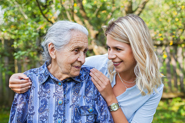 Elderly female with young lady touching shoulder