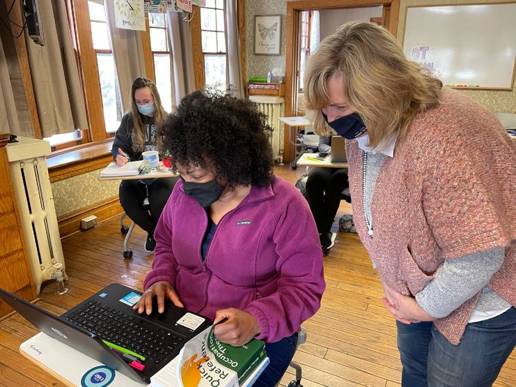 female student at computer with faculty helping