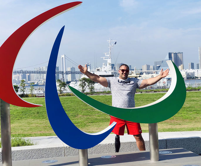 Jake standing in front of Paralympic sculpture in Tokyo