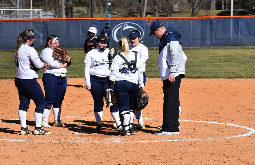 Women's softball players convene on the mound