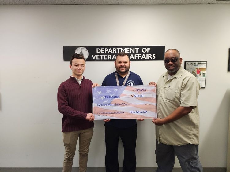 Students hold a check written out to MilitaryShare Program